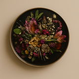 Decorative plate with a colorful arrangement of pressed flowers on a beige background